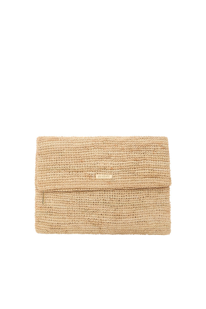 Angled flat lay of Cannes Clutch showing straw raffia, fold-over flap with gold logo plaque and zipper on white background