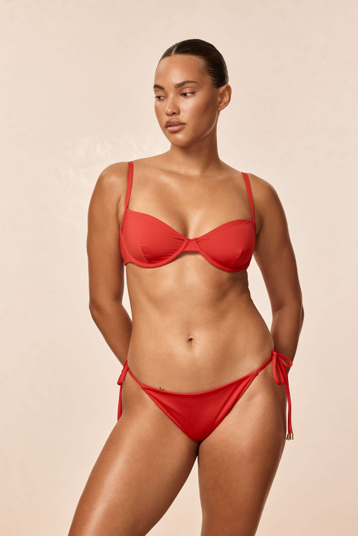Front view of Capri Top in Chili Pepper on model showing underwire cups and adjustable straps with beige background