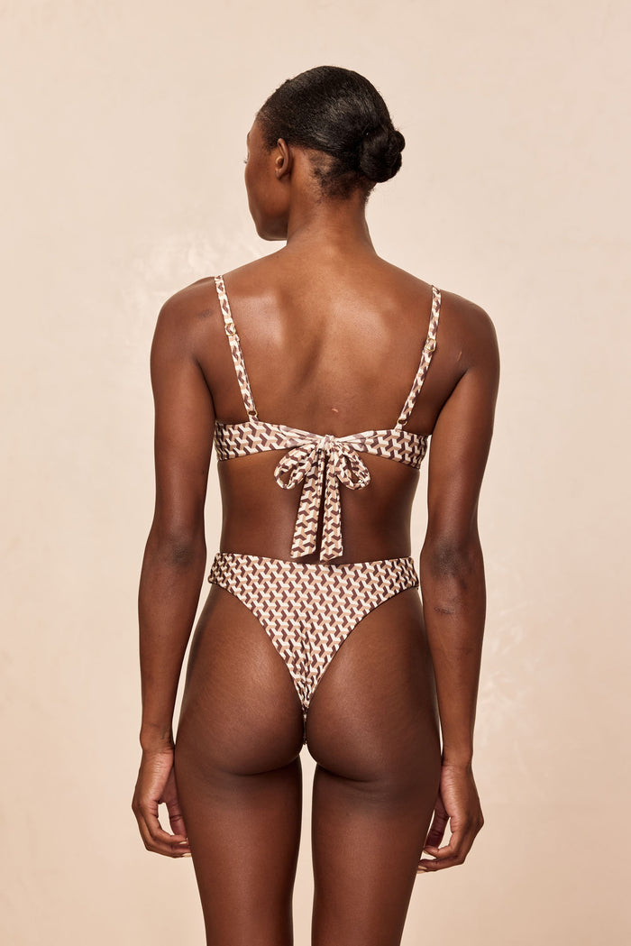 Rear view of Capri Top in Husk Geo showcasing tied-back underwire top with thin adjustable straps on a neutral beige background