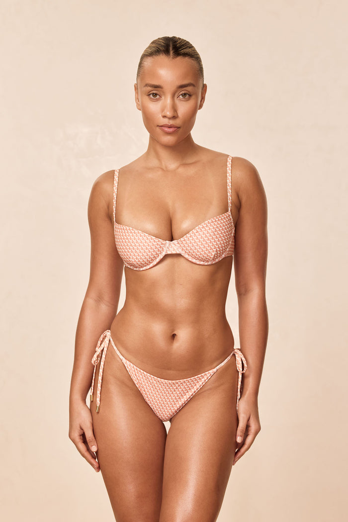 Front view of Capri Top Micro Geo showing underwire cups, adjustable straps, and peach micro-geo print on beige background