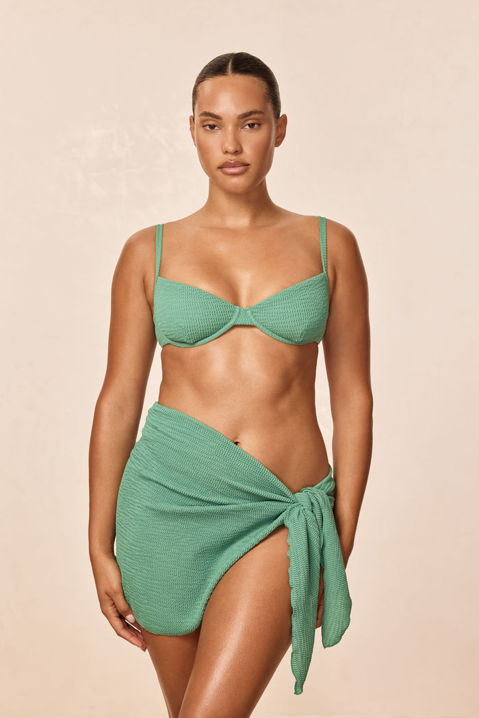 Front view of Capri Top in Pond Crinkle on model showing underwire cups, adjustable straps, and matching sarong