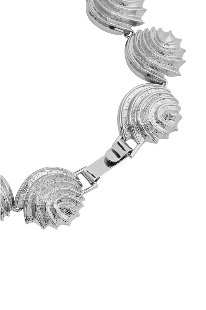 Close-up of Cayman Necklace in silver showcasing ridged, shell-shaped linked segments and fold-over clasp on white background