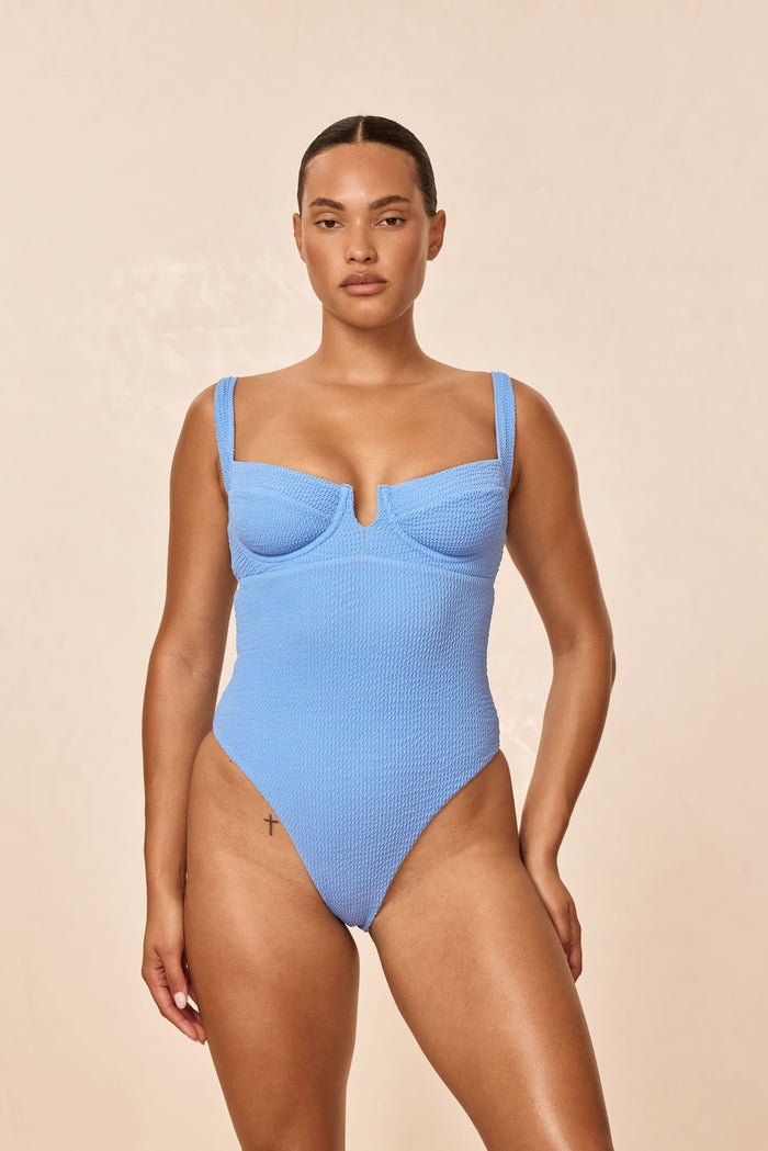 Front of Clovelly One Piece in Azure Crinkle with textured fabric, underwire cups, center V-notch and high-cut leg on beige