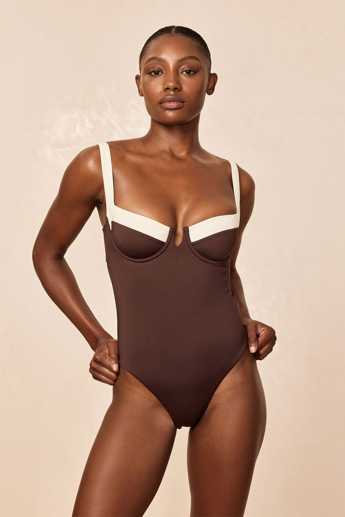 Front view of Clovelly One Piece in espresso/ivory with underwire cups, contrast ivory straps, and high-cut leg on model