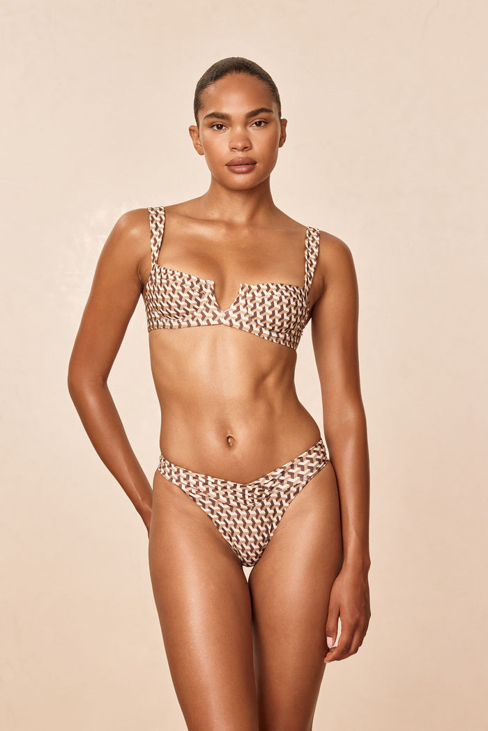 Front view of Clovelly Top in Husk Geo print on model showing V-notch square neckline and wide straps against a beige background