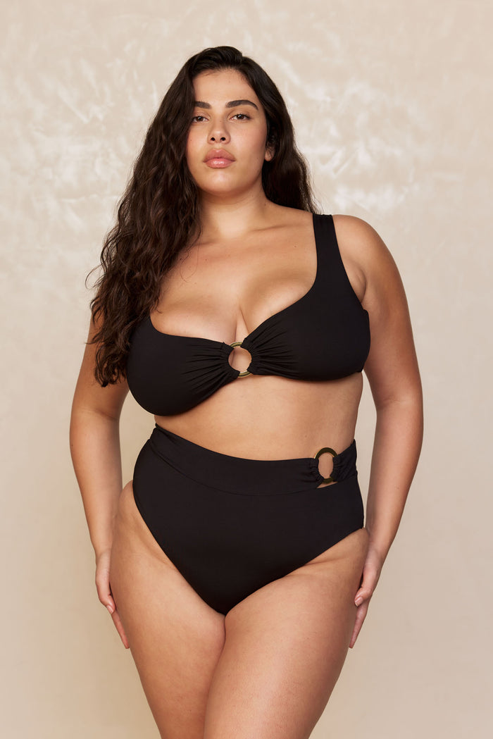 Front view of Costa Rica Bottom in black on a plus-size model, high-waisted full coverage with gold ring accent at side