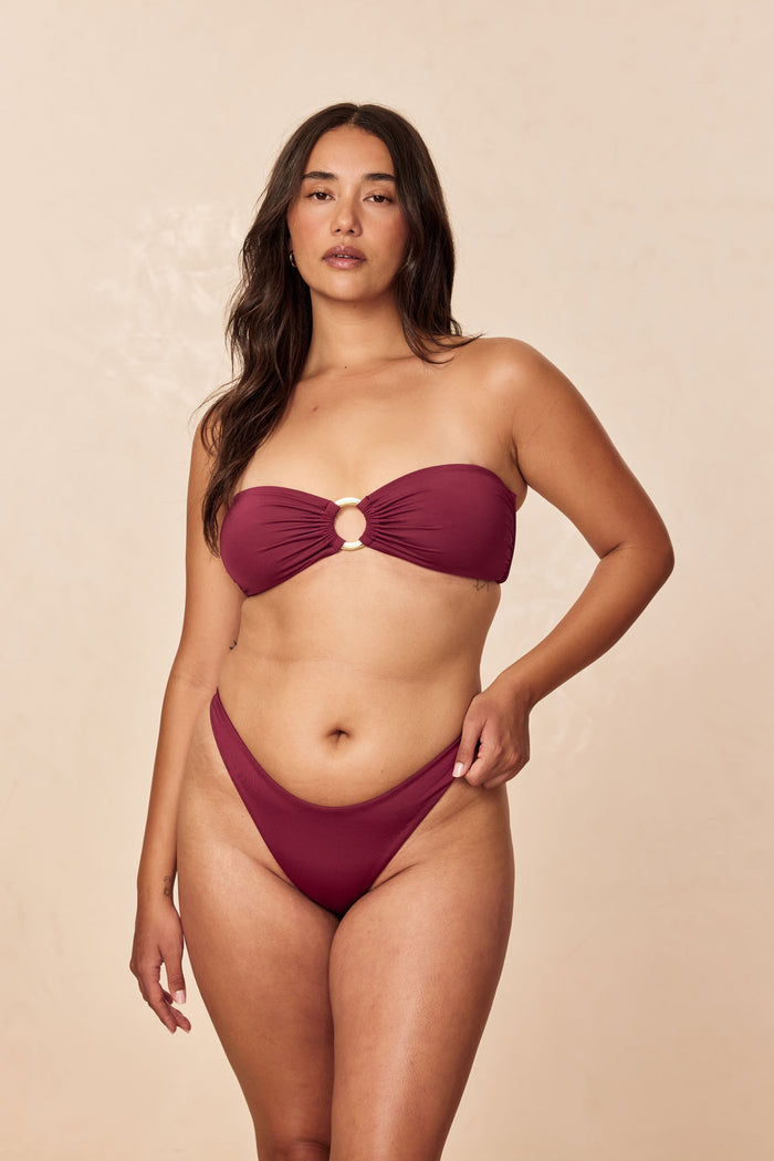 Front of Costa Rica Top in Fig showing strapless bandeau with gold center ring on model against beige background