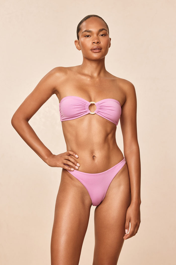 Front view of Costa Rica Top in Moonlight showing gold center ring and removable halter strap on model, beige backdrop