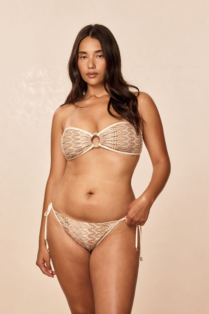 Front view of Costa Rica Top in Porto Cervo Gold on model, strapless bandeau with center gold ring on beige background