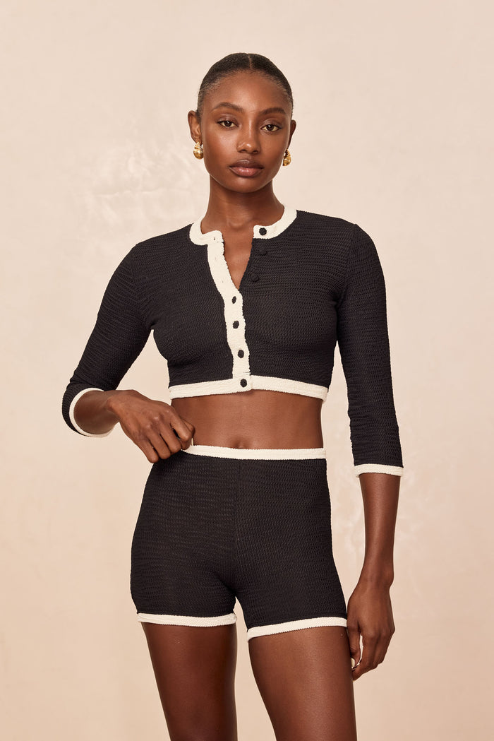 Front view of Santa Cruz Short on model showcasing textured crinkle fabric, high-waist boxer fit and ivory trim on beige background
