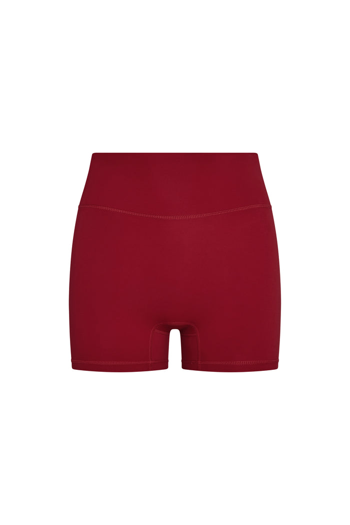 Front view of Elysian Short in cherry showing high doubled waistband, booty short cut with front pocket on white background