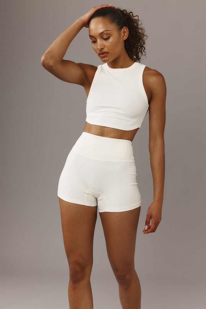 Front three-quarter view of Elysian Short 4.5-inch in Ivory rib on model showing high-rise waistband on gray background