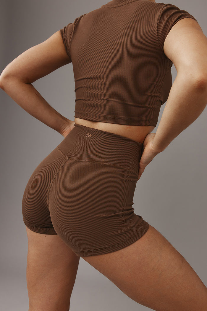 Three-quarter rear of Elysian Short 4.5 inch in Cliffside rib showing high-rise waistband and contoured seam on gray background