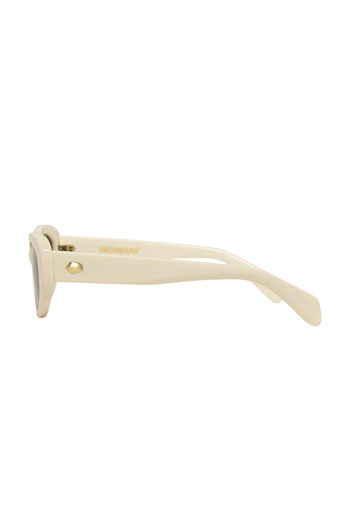 Side view of Es Vedrá sunglasses in ivory showcasing gold MONDAY logo on the temple and gold hinge on white background