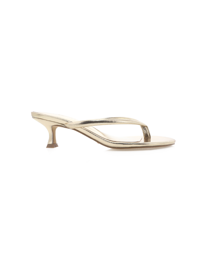 Side view of ESTI - GOLD METALLIC thong stiletto with metallic thin straps and low 2.09in kitten heel on white background