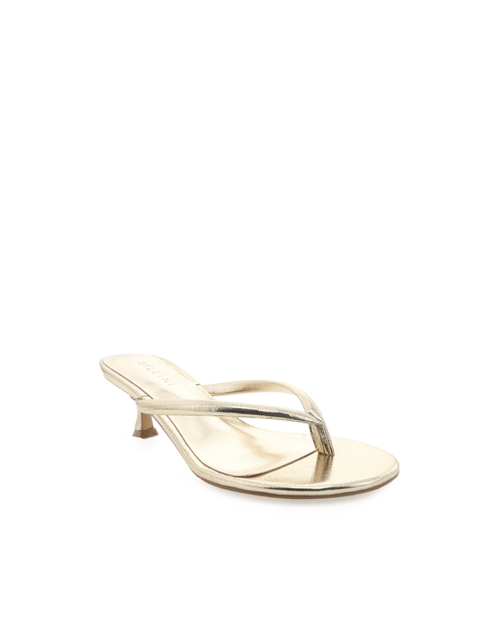 Angled view of Esti gold metallic thong stiletto with low kitten heel, thin thong straps on white background