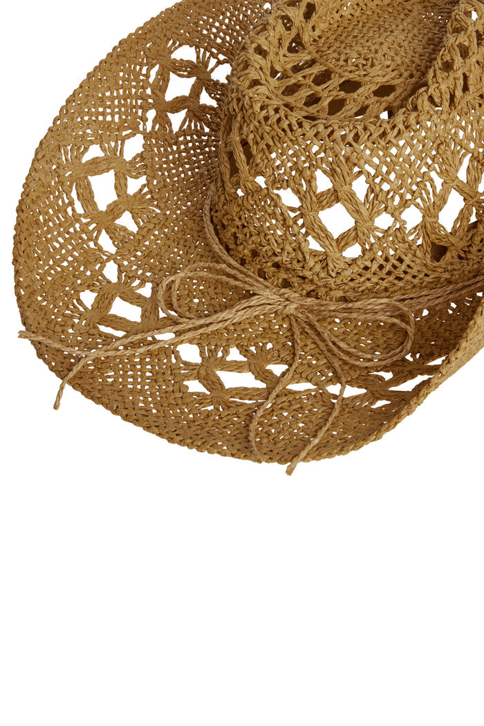 Angled close-up of Exuma rattan hat showcasing open-weave crochet pattern, braided tie, natural tan on white background