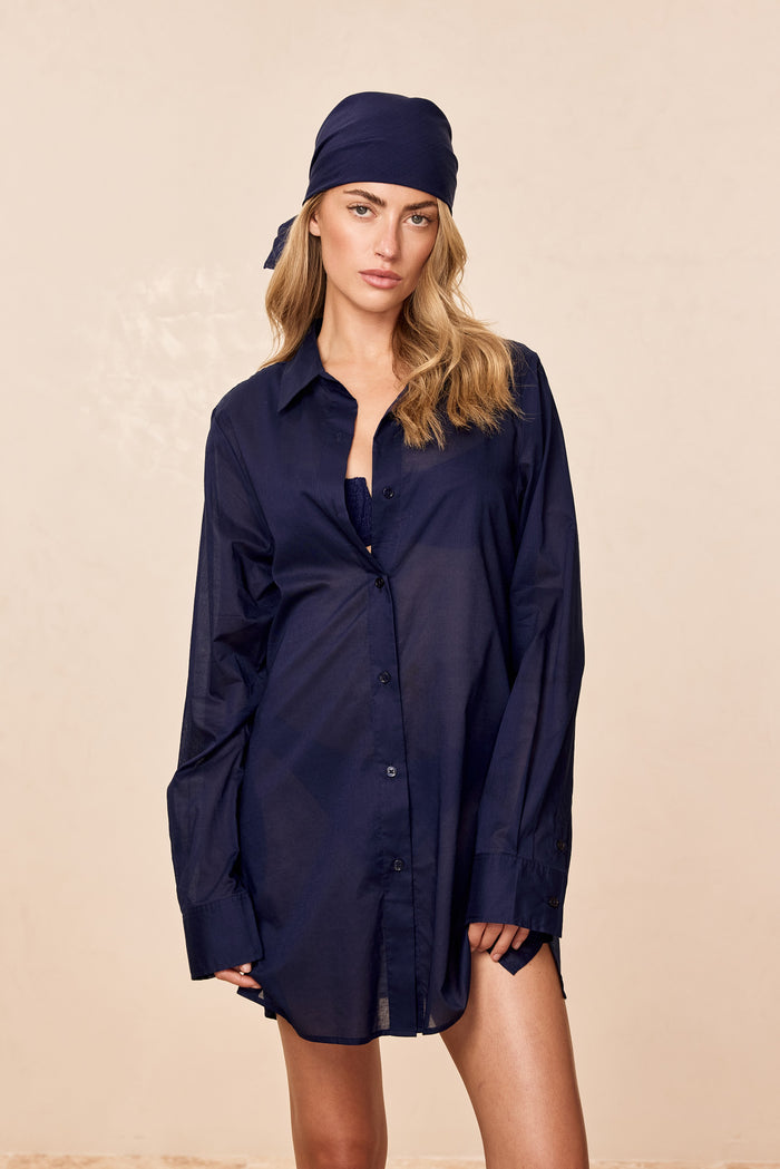 Front view of Fiji Tunic (Midnight Cotton Voile) showing semi-sheer fabric, button-front and side slits on a beige background