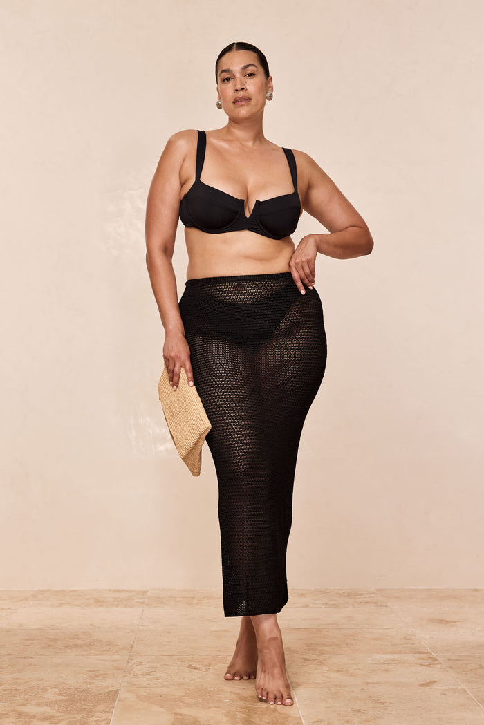 Front view of Fontelina Midi Skirt in Black Treble Knit on a plus-size model showcasing sheer crochet open-knit fabric and fitted hips