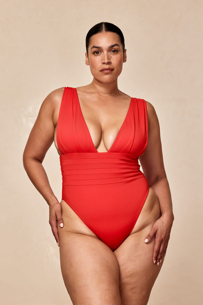 Front of Florence One Piece in Chili Pepper showing deep V-neck, pleated waist, wide shoulder straps on neutral background