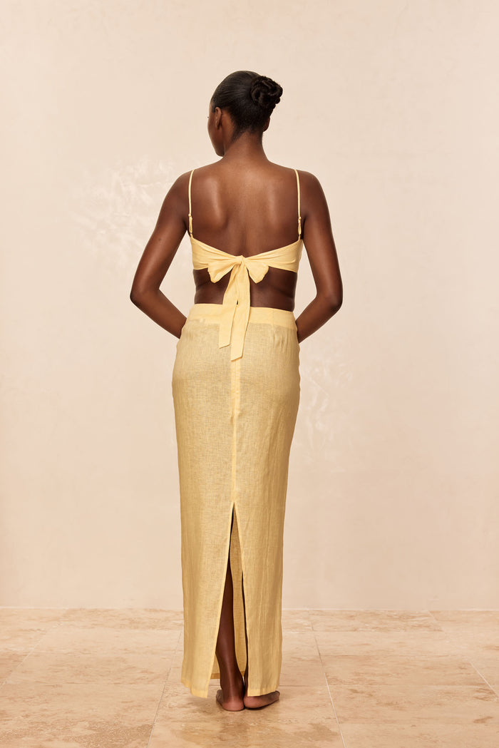 Back view of Fontelina Linen Skirt in Honey showing high waist and center back slit on a model against a neutral studio backdrop