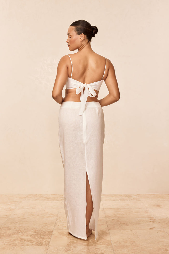 Back view of Fontelina Linen Skirt in white showing center back slit and high waist on a neutral studio background