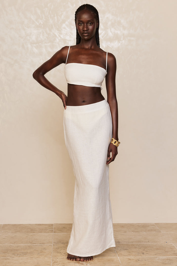 Front view of Fontelina Linen Skirt in white showcasing high waist, slim maxi column silhouette and semi-sheer linen on beige studio background