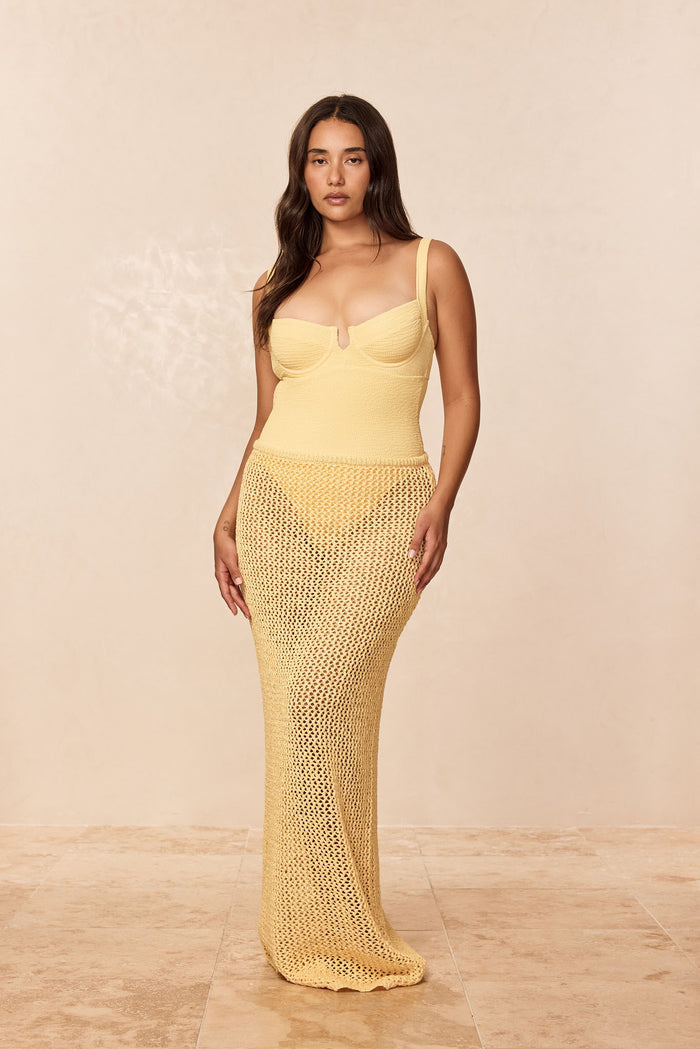 Front view of Fontelina Skirt in honey petit crochet on model, fitted waist and long open knit maxi, beige background
