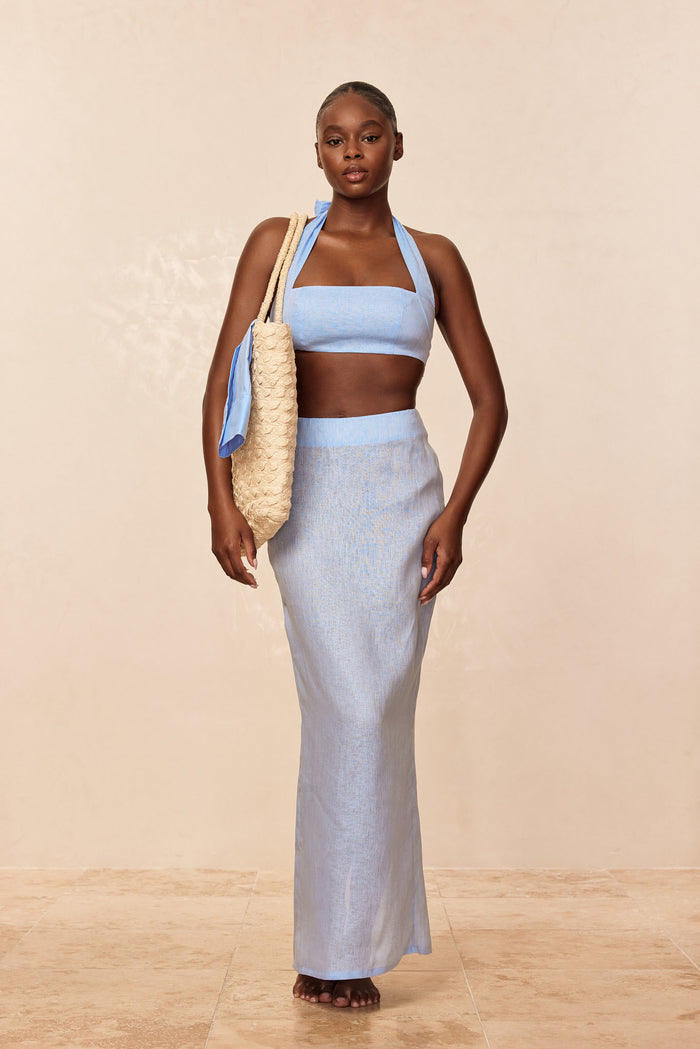 Front view of Fontelina skirt in Sky Linen, high-waist ankle-length slim linen silhouette on model against beige background