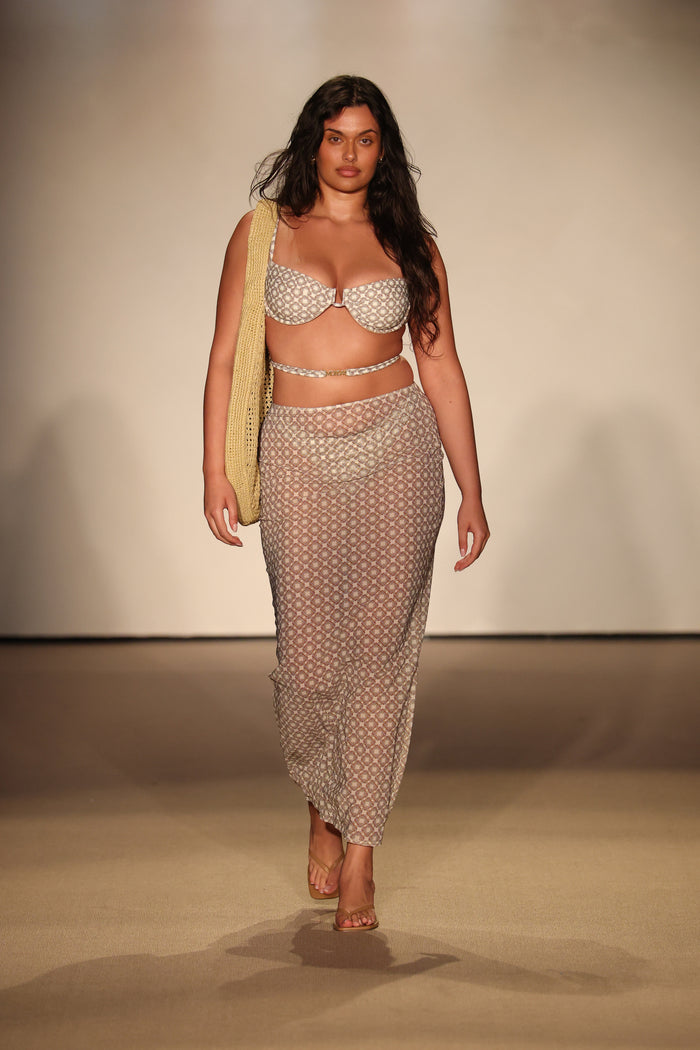 Front view of Cala Roja Top in Tile Geo, showing underwire balconette cups, wrap-around strap and matching sheer skirt on beige runway
