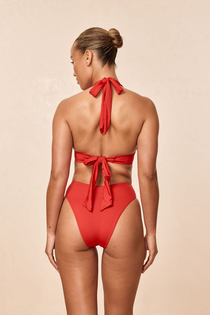 Back view of Formentera Bottom in Chili Pepper showing high-waist, high-cut leg and cheeky coverage on model, beige background
