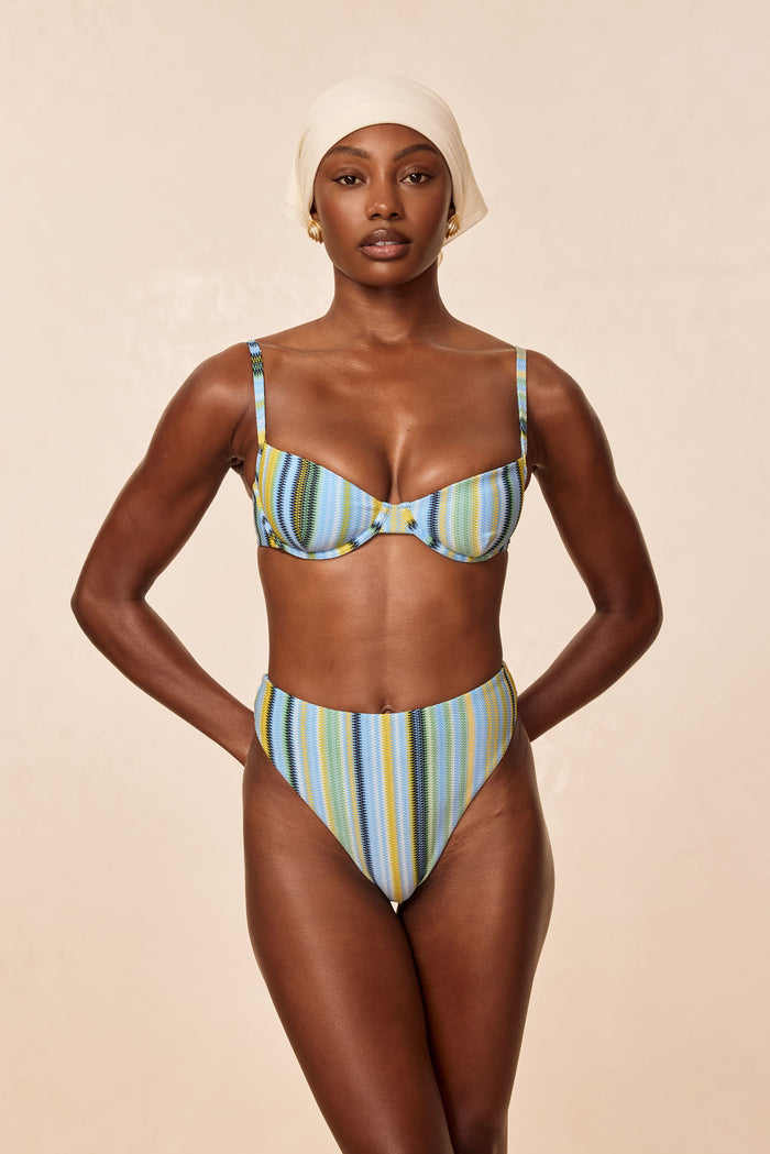 Front view of Formentera Bottom in Sardinia Stripe Azure showcasing high-waisted, high-leg cheeky fit on model against a beige studio background