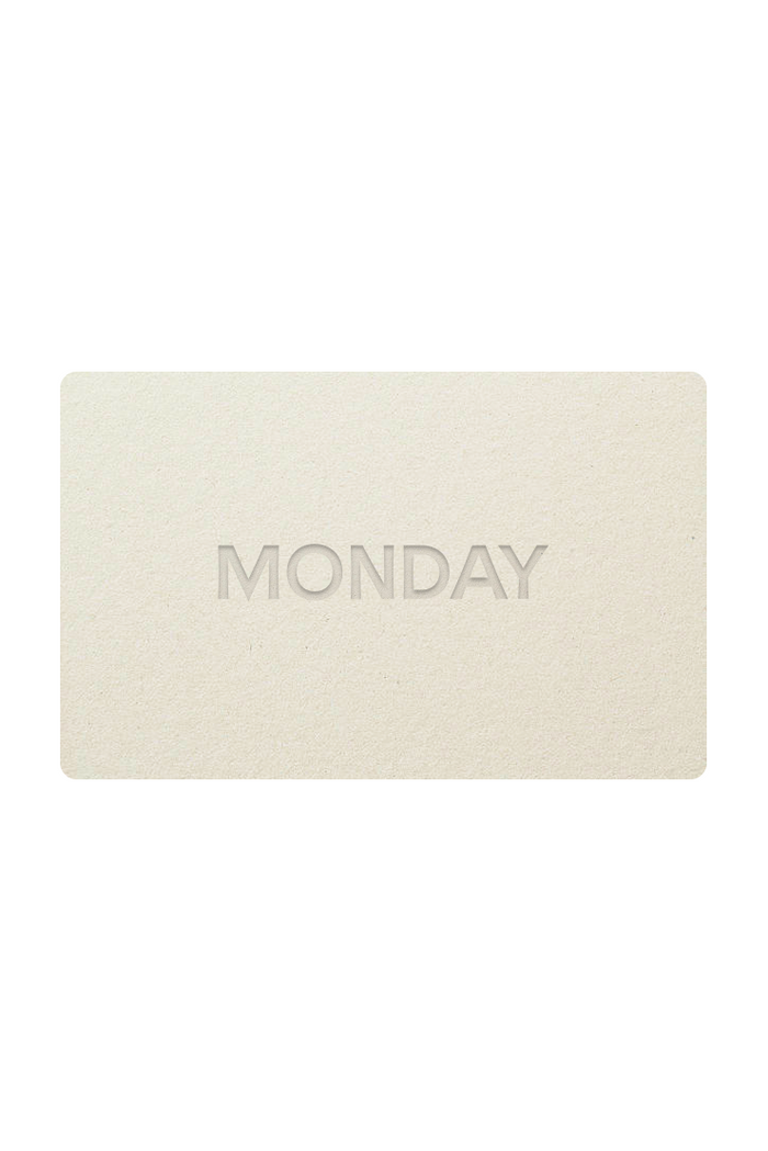 Straight-on view of Monday Swimwear gift card showing embossed "MONDAY" on a textured beige card with white background