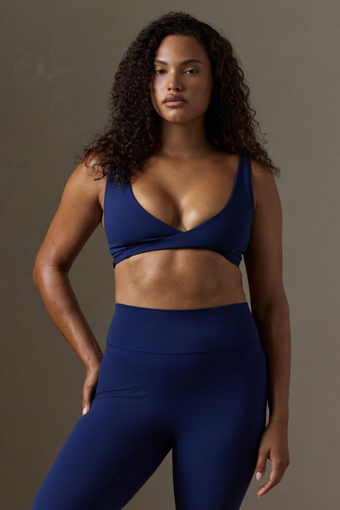 Front view of Griffith Bra in Midnight Jersey on model, twist-front V neckline and wide straps against neutral background