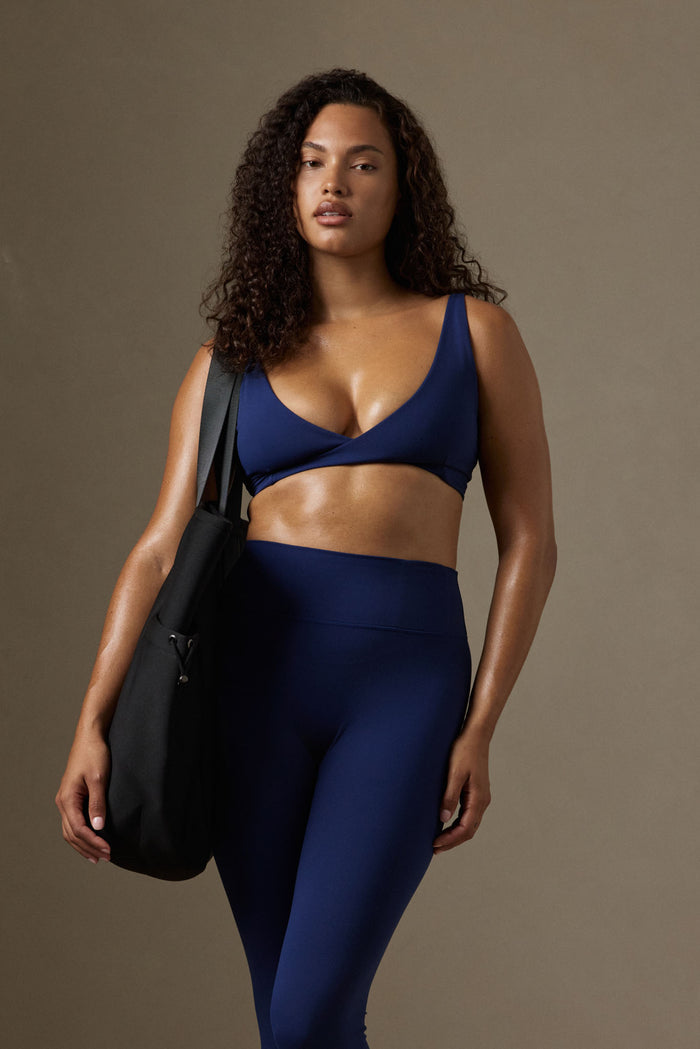 Front view of Griffith Bra in Midnight Jersey showing twist-front neckline and adjustable shoulder straps on model against a neutral studio background