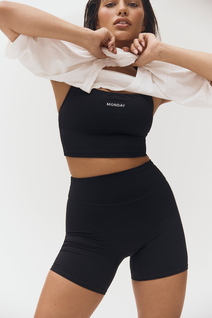 Front view of Griffith Short 6.25-inch in black showing high-rise waistband and fitted biker length on model