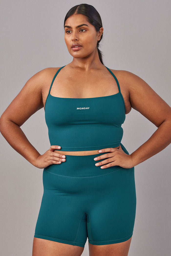 Front view of Griffith Short 6.25-inch in Evergreen on a plus-size model showing high waist and mid-thigh length on gray background