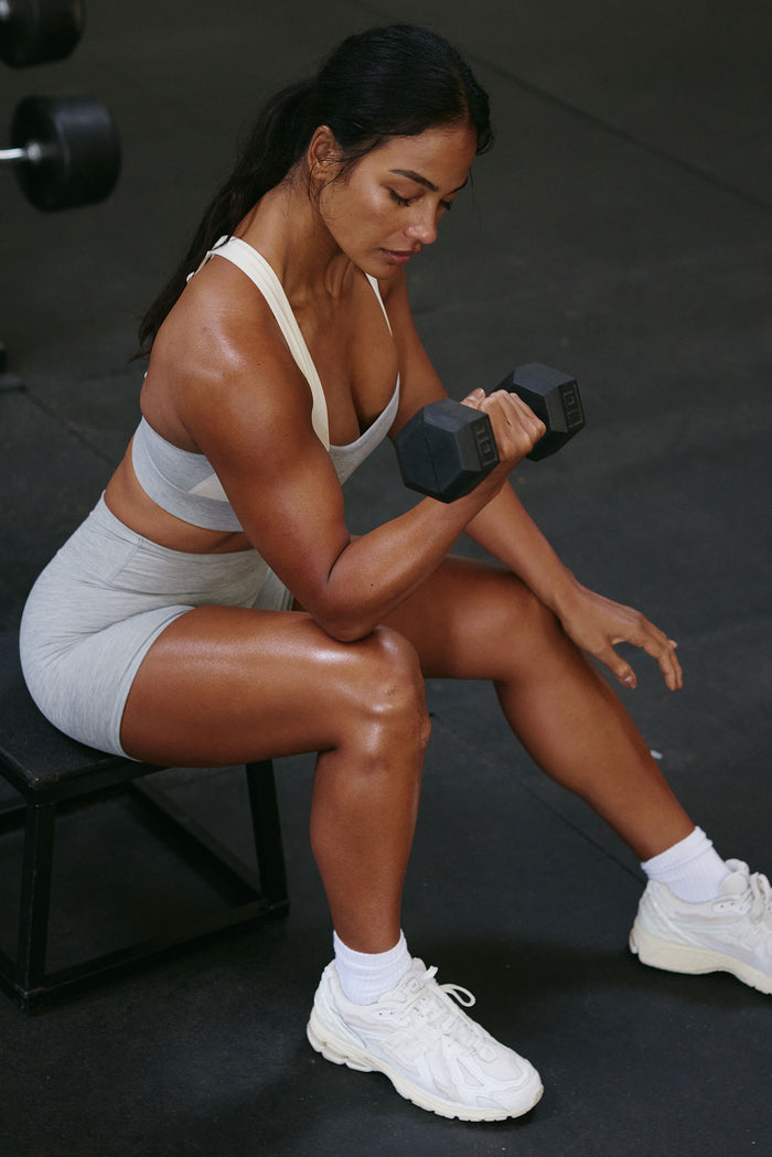 Side view of Griffith Short 6.25 inch in heather grey showcasing fitted high-rise silhouette on model against gym floor