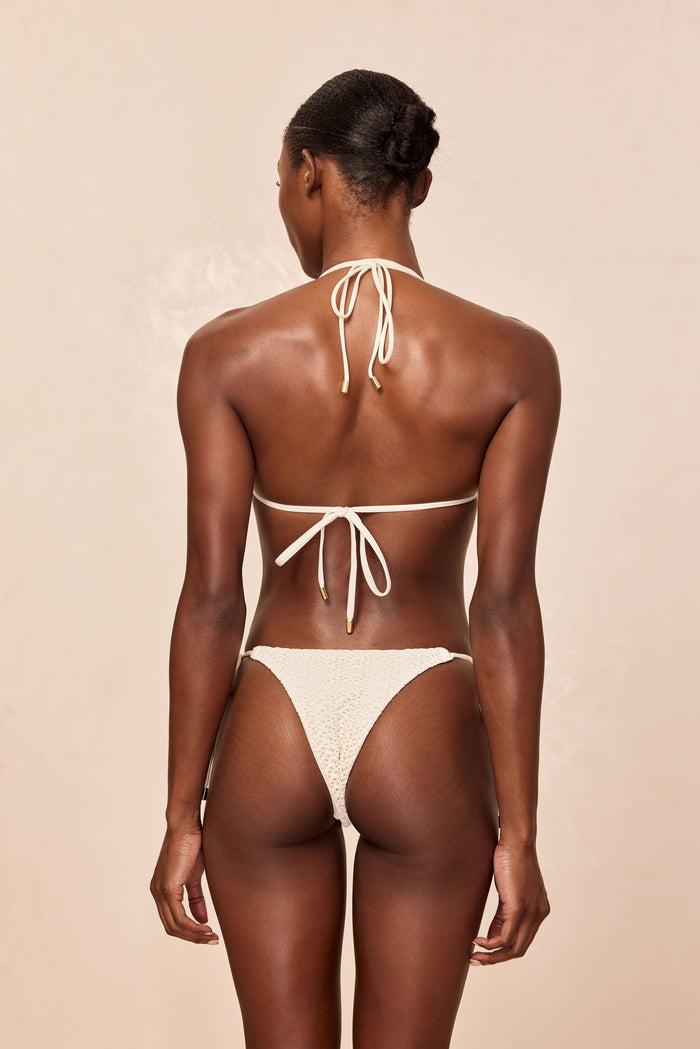 Back view of Hanalei Top in Ivory Crochet showcasing halter and back ties with crochet texture against beige background