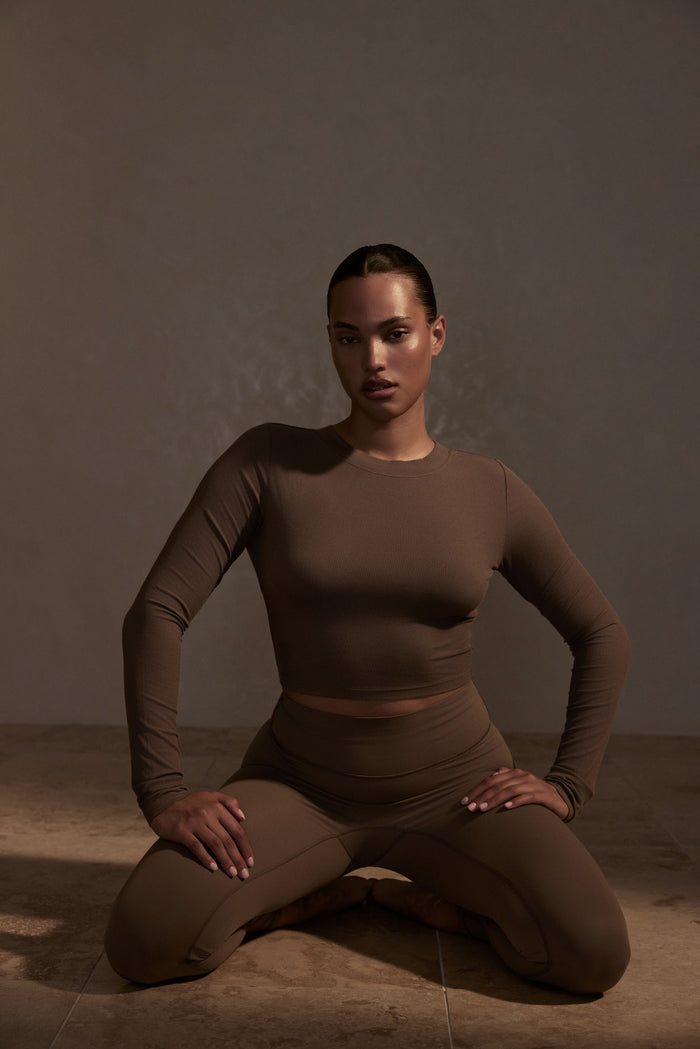 Front of Hayworth Long Sleeve top in Stone on model, showing ribbed lightweight fabric and fitted cropped silhouette