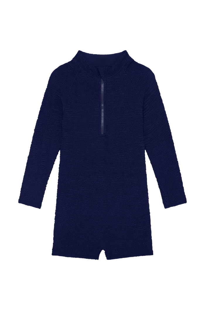 Front of Hilo One Piece in Midnight Crinkle with center-front zipper, long sleeves, short legs on black background