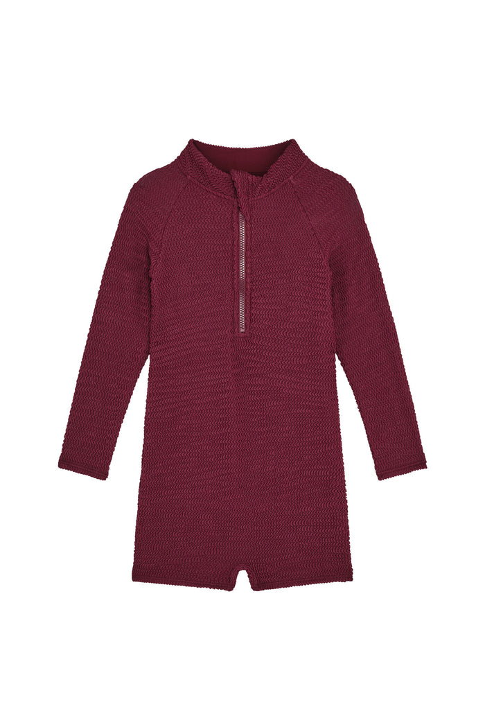 Front view of Hilo one-piece kids swimsuit in fig crinkle with long sleeves and center front zipper on white background