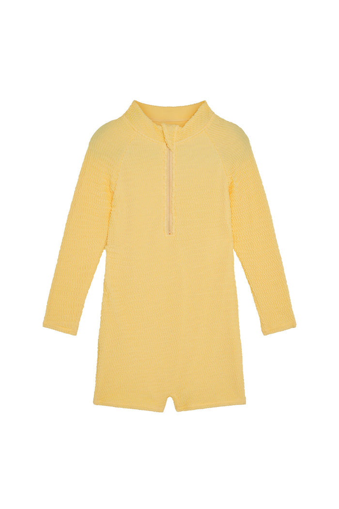 Front view of Hilo One Piece Kids in Honey Crinkle, crinkle textured fabric with long sleeves, front zip, and short legs on white background