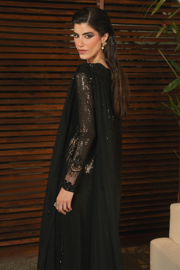 Side view of NAQSHI Horleyn black formal outfit highlighting short slit, hanging details, fitted sleeves, and smooth straight trouser fit.