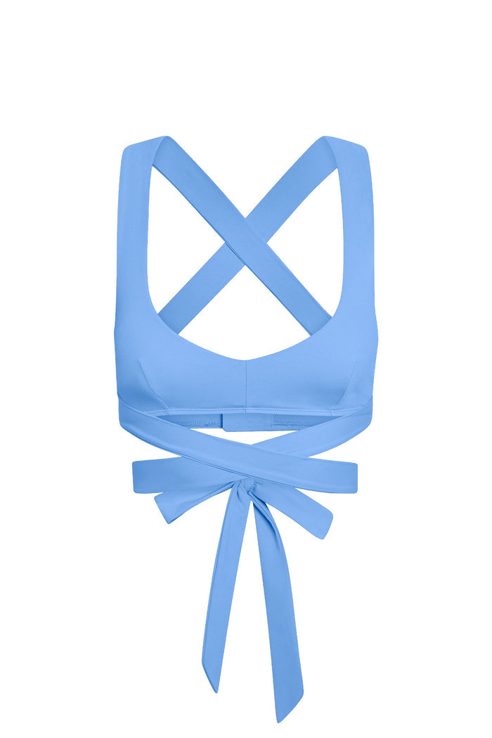 Light blue women's wrap sports bra with crisscross straps and long tie-back bow