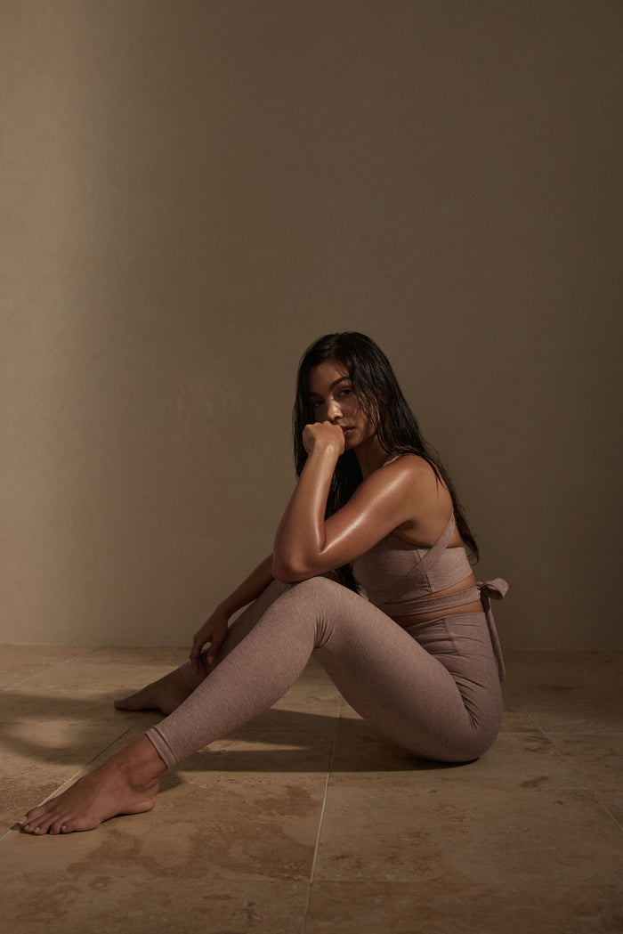 Seated side view of Acadia Legging in Heather Mauve on model showing high-rise, full-length fitted silhouette and heathered texture