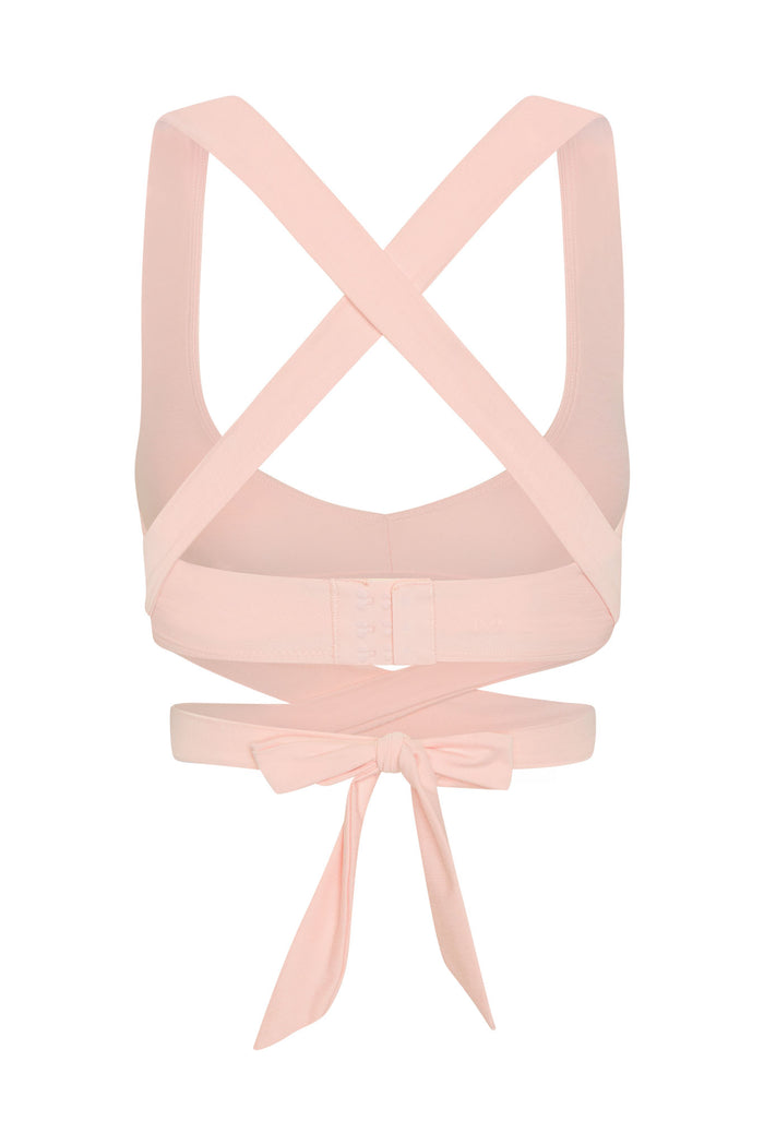 Back view of Hudson Bra in heather powder pink showing crossed straps, hook and eye closure and long tie on white