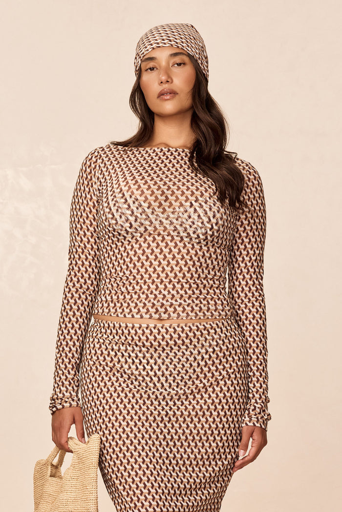 Front view of Ipanema Top Husk Geo Mesh showcasing sheer long sleeves and brown geometric pattern on a neutral beige background