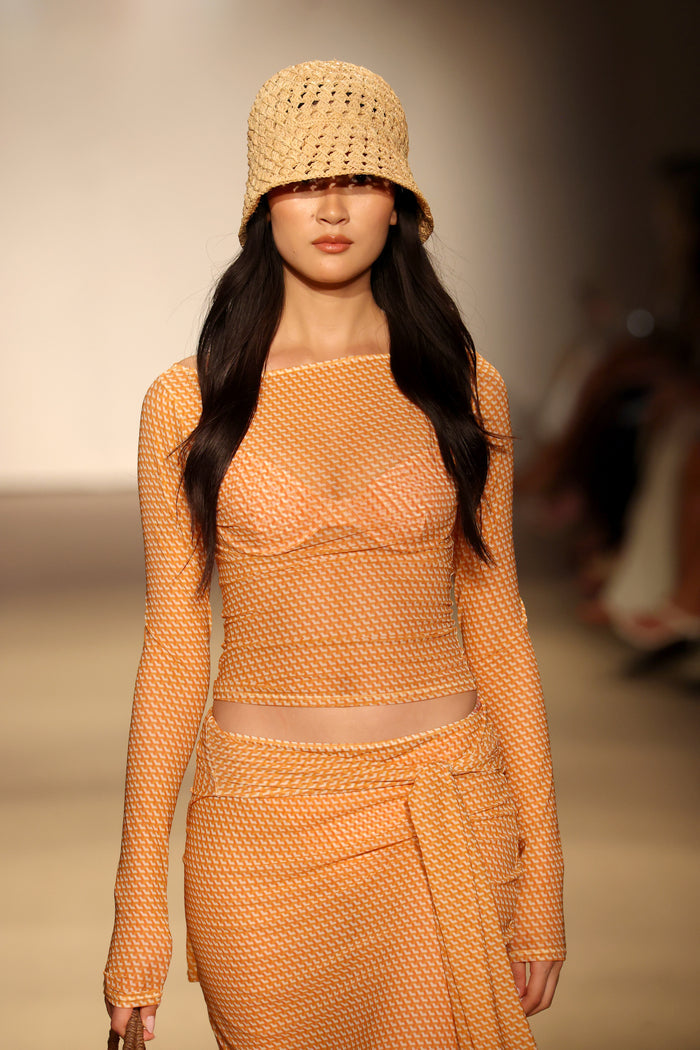 Front view of Ipanema Top - Micro Geo Mesh showcasing orange micro-geo mesh fabric, long sleeves, and cropped fit on a runway