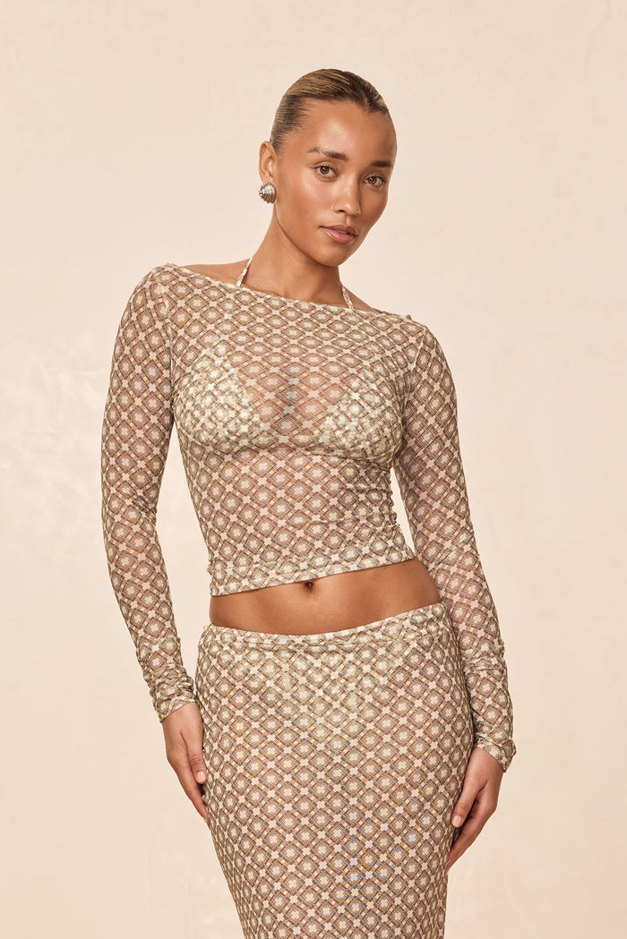 Front view of Ipanema Top in Tile Geo mesh showcasing sheer long sleeves, boat neckline, and fitted cropped fit on model against beige background